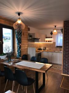 a kitchen with a wooden table and chairs at Domek na Hubce 1 Blisko Velo Czorsztyn in Maniowy