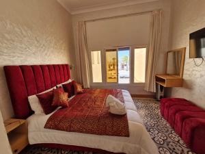 a hotel room with a large bed with a red headboard at Riad Rabat Laalou in Rabat
