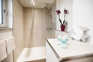 a white bathroom with a shower and a sink at Kampowski Apartments Bad Nauheim in Bad Nauheim