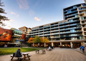 a man sitting on a bench in front of a building at Beacon Guest Rooms Sandyford in Sandyford +30 photos