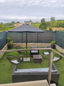 a patio with a table and chairs and an umbrella at Chalet con vista a las Islas Cíes in Sanxenxo
