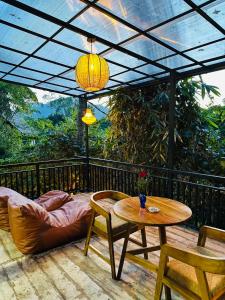 a patio with a table and chairs on a deck at La Casa Bella in Ella