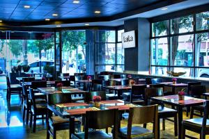 a restaurant with tables and chairs and windows at LaiLa Hotel Mexico City Reforma in Mexico City