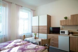 a bedroom with two beds and a table and a microwave at Pension Gábi in Františkovy Lázně