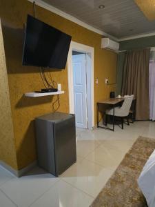 a living room with a flat screen tv on a wall at RIER Guesthouse in Pretoria