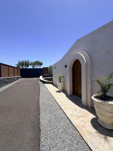 a building with a door and two potted plants at Villa Majora - Piscina climatizada in Tuineje