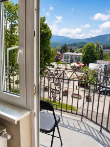 a chair on a balcony with a view of a city at Apartamenty ABRACADABRA in Ustroń