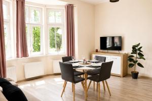 a living room with a table and chairs and a tv at Apartamenty ABRACADABRA in Ustroń