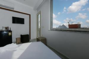 a bedroom with a white bed and a large window at Pyramids Giza inn in Cairo +6 photos