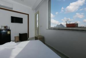 a bedroom with a white bed and a window at Pyramids Giza inn in Cairo