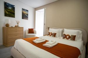 a bedroom with a bed with two towels on it at Douro River Apartment in Vila Nova de Foz Coa