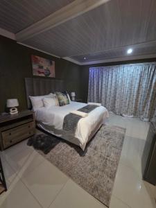 a bedroom with a large bed and a window at RIER Guesthouse in Pretoria
