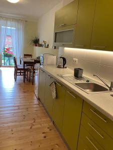 a kitchen with a sink and a table with a dining room at Apartmán Pod Jánským Vrchem in Javorník