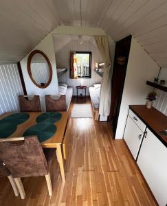 ein Wohnzimmer mit einem Tisch in einem winzigen Haus in der Unterkunft The Crows Nest in Hirtshals