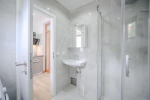 a white bathroom with a sink and a shower at L&S House in Prague