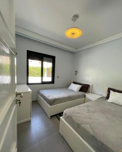 a bedroom with two beds and a window at VILLA EVASION Aglou Center in Zaouia Sidi Ouaggag +19 photos