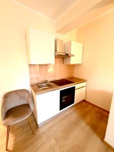 a small kitchen with a sink and a chair at Le Charme Luxury Suite in Patti