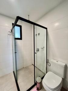 a bathroom with a toilet and a glass shower at Flat Elegante, Confortável e Com Uma Bela Vista in Campo Grande +13 photos
