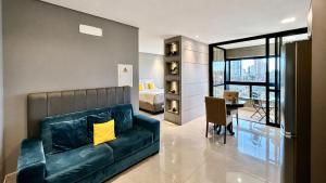 a living room with a couch and a dining room at Flat Elegante, Confortável e Com Uma Bela Vista in Campo Grande