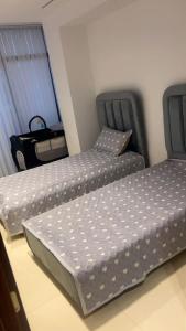 two beds sitting next to each other in a room at Ayden Residence Béjaïa in Bejaïa