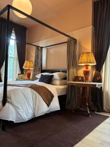 a bedroom with a canopy bed with two lamps at The Truitt in Saint Louis