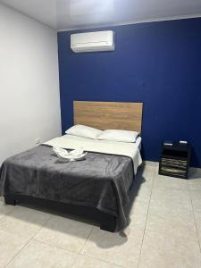 a bedroom with a bed with a blue wall at Hotel Real del Valle in Valledupar +90 photos