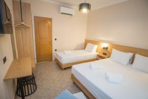 a hotel room with two beds and a table at Sofia and Soul Studios in Kalamitsi