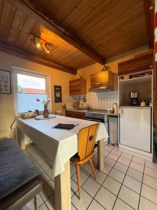 a kitchen with a table and a refrigerator at Ruhiges Elbhäuschen nahe Hamburg in Hollern-Twielenfleth