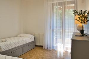 a white bedroom with a bed and a window at Renzo e Lucia - la Terrazza Panoramica in Barzio +32 photos