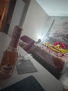 a bottle of beer sitting on a table next to a bed at The Paris Rooms B&B in Reggio di Calabria