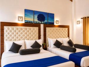 two beds in a hotel room with two beds at Mounts Edge Regency in Mahiyangana +42 photos