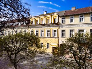 a large yellow building with trees in front of it at Pension Gábi in Františkovy Lázně