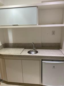 a kitchen with a sink and white cabinets at Ondi Cosmopolitan in Palmas
