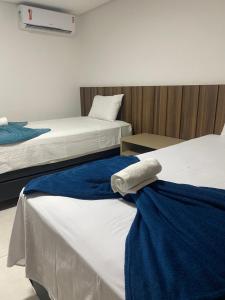 a hotel room with two beds with blue and white sheets at Ondi Cosmopolitan in Palmas