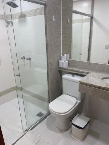 a bathroom with a toilet and a glass shower at Ondi Cosmopolitan in Palmas