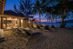 a group of chairs and tables on the beach at night at Beachfront A405 Seaview Studio Rawai Phuket in Ban Saiyuan (1)