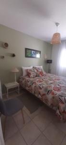 a bedroom with a bed and a chair in it at Chambre d'hôtes Thé ou Café in Auray