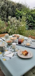 a table with a blue table cloth with food on it at Chambre d'hôtes Thé ou Café in Auray