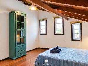 a bedroom with a bed and a green cabinet at Pousada Solar das Pétalas - Florianópolis/SC in Florianópolis