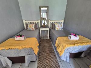 a bedroom with two beds with yellow sheets and a mirror at Midvaal Guesthouse in Meyerton +60 photos