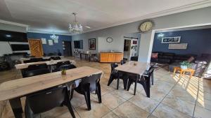 a dining room and living room with tables and chairs at Midvaal Guesthouse in Meyerton