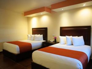 two beds in a hotel room with two beds at Hotel Buen Valle in Torreón