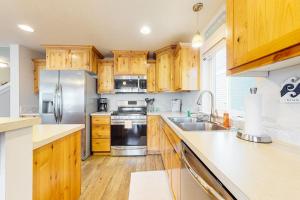 a kitchen with wooden cabinets and stainless steel appliances at Dory Pointe Dream in Pacific City +15 photos