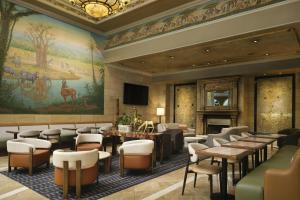 a lobby with tables and chairs and a mural at The Davenport Tower, Autograph Collection in Spokane