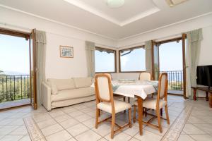 a dining room with a table and chairs and a couch at Limoneto by Espresso Rentals in Massa Lubrense