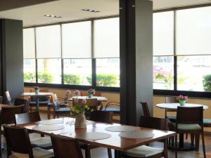 a restaurant with tables and chairs and large windows at Hotel Buen Valle in Torreón