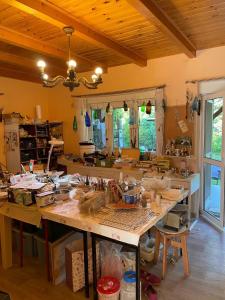 a large kitchen with a large table with lots of clutter at Artystycznie nad Bugiem 1 in Gnojno