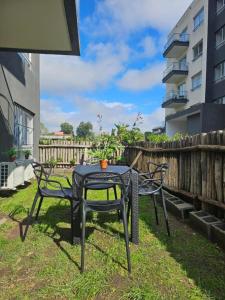 a table and two chairs sitting on the grass at Sunny Stay Ezeiza in Ezeiza