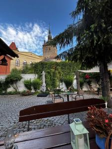 a bench in a courtyard with a building in the background at Taschler Haus in Sighişoara