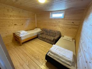 ein Zimmer mit einem Bett und einer Couch in einer Hütte in der Unterkunft Room 1 in Hästveda